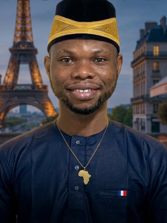 Richard sorrindo, com kufi tradicional e pingente do mapa da África, com a Torre Eiffel ao fundo
